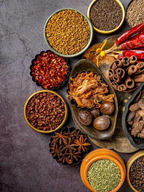 A top view of various Indian spices and seasonings on a table